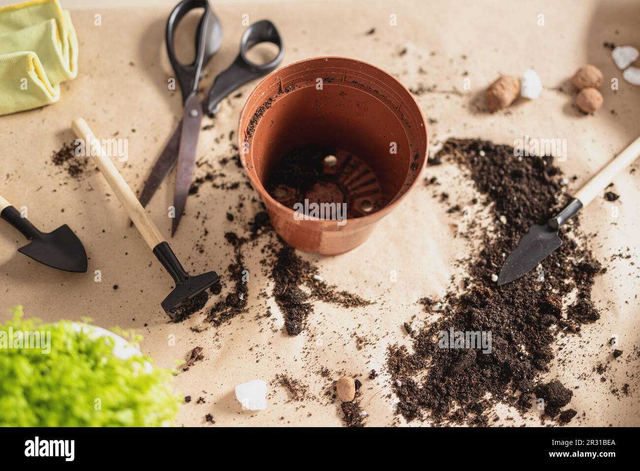 Leere Töpfe, Erde, Gartengeräte auf Kunsthandwerkstoff-Hintergrund Stockfoto