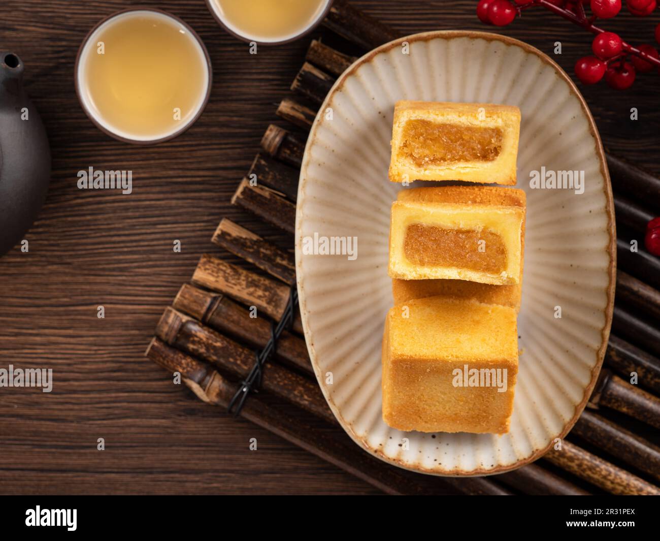 Köstliches taiwanesisches berühmtes Ananaskuchen Gebäck als Dessert auf einem Teller auf einem Holztisch mit heißem Tee. Stockfoto
