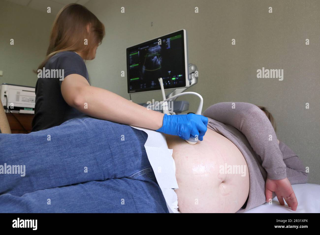 Ultraschalluntersuchung des Feten einer schwangeren Frau. Apparatur zur Ultraschalluntersuchung. Ultraschallscanner. Stockfoto