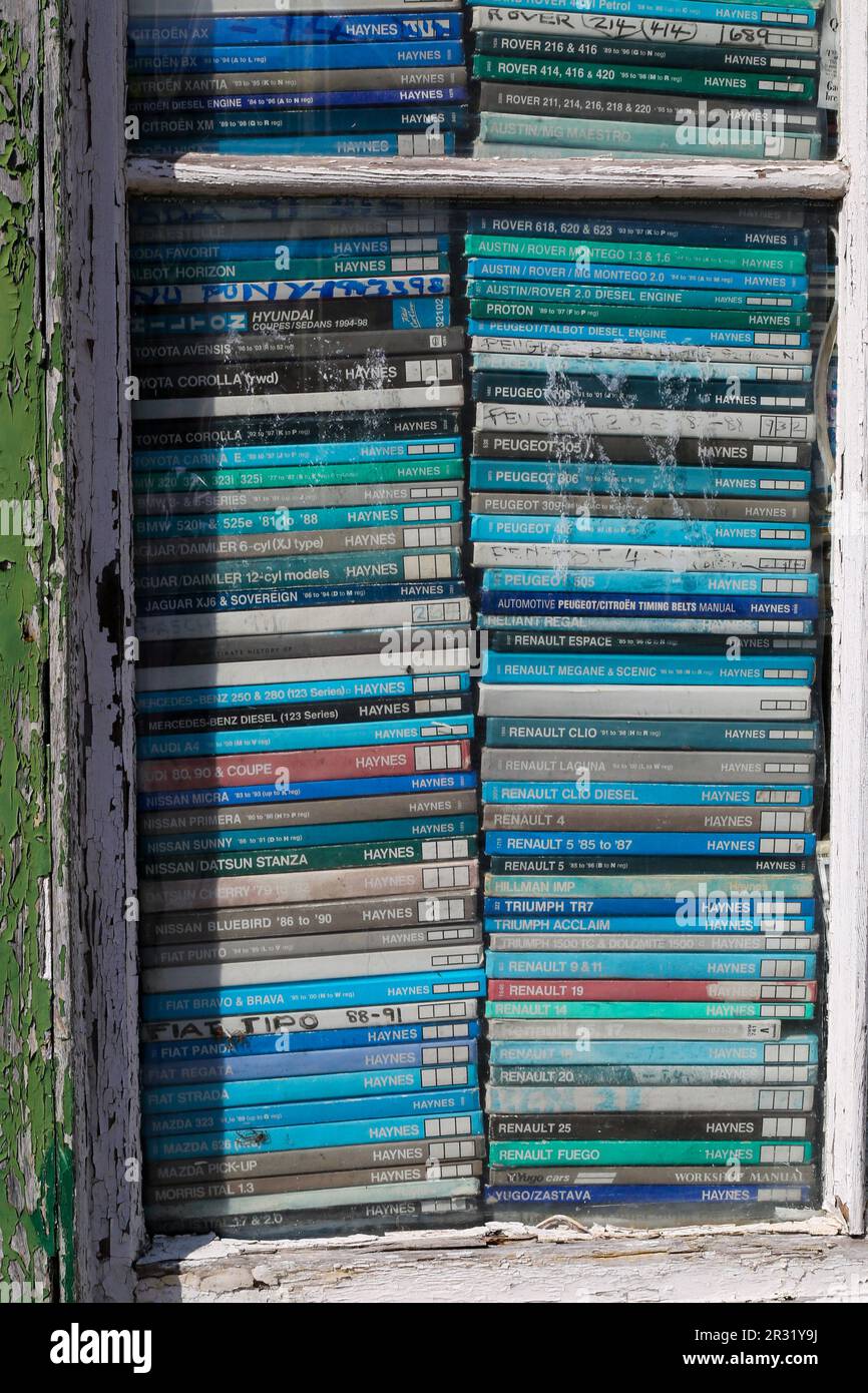 Alte und verblasste Werkstatthandbücher in einem Schaufenster. Salisbury 2023. Stockfoto