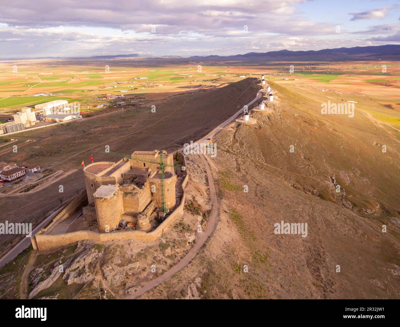 Molinos de Consuegra con el Castillo de La Muela al Fondo, Cerro Calderico, Consuegra, Provincia de Toledo, Kastilien-La Mancha, Spanien. Stockfoto