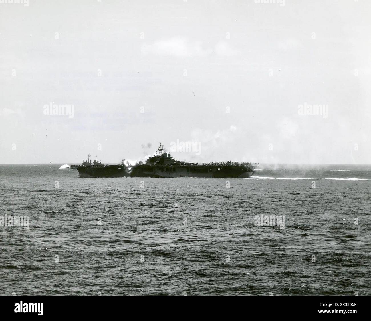 Ein bemerkenswertes Foto, das zeigt, wie die USS Essex von einem Kamikaze östlich von Luzon, Philippinen, getroffen wird, 25. November 1944. Die Rauchspur aus dem Flugzeug ist noch immer in der Luft sichtbar, was zum Aufprall und zur Explosion führt. Als Japan Ende 1944 mit einer Niederlage konfrontiert war, entschied es sich, US-Schiffe mit Selbstmordattentaten, bekannt als Kamikaze, zu zerstören. Diese Angriffe waren eine starke physische und psychologische Waffe und versenkten insgesamt 47 Schiffe zu einem Preis von mehr als 3000 Piloten und Flugzeugen. Ende 1944 war die US-Marine so groß, dass die Verluste unbedeutend waren und den Verlauf des Krieges nicht veränderten. Stockfoto