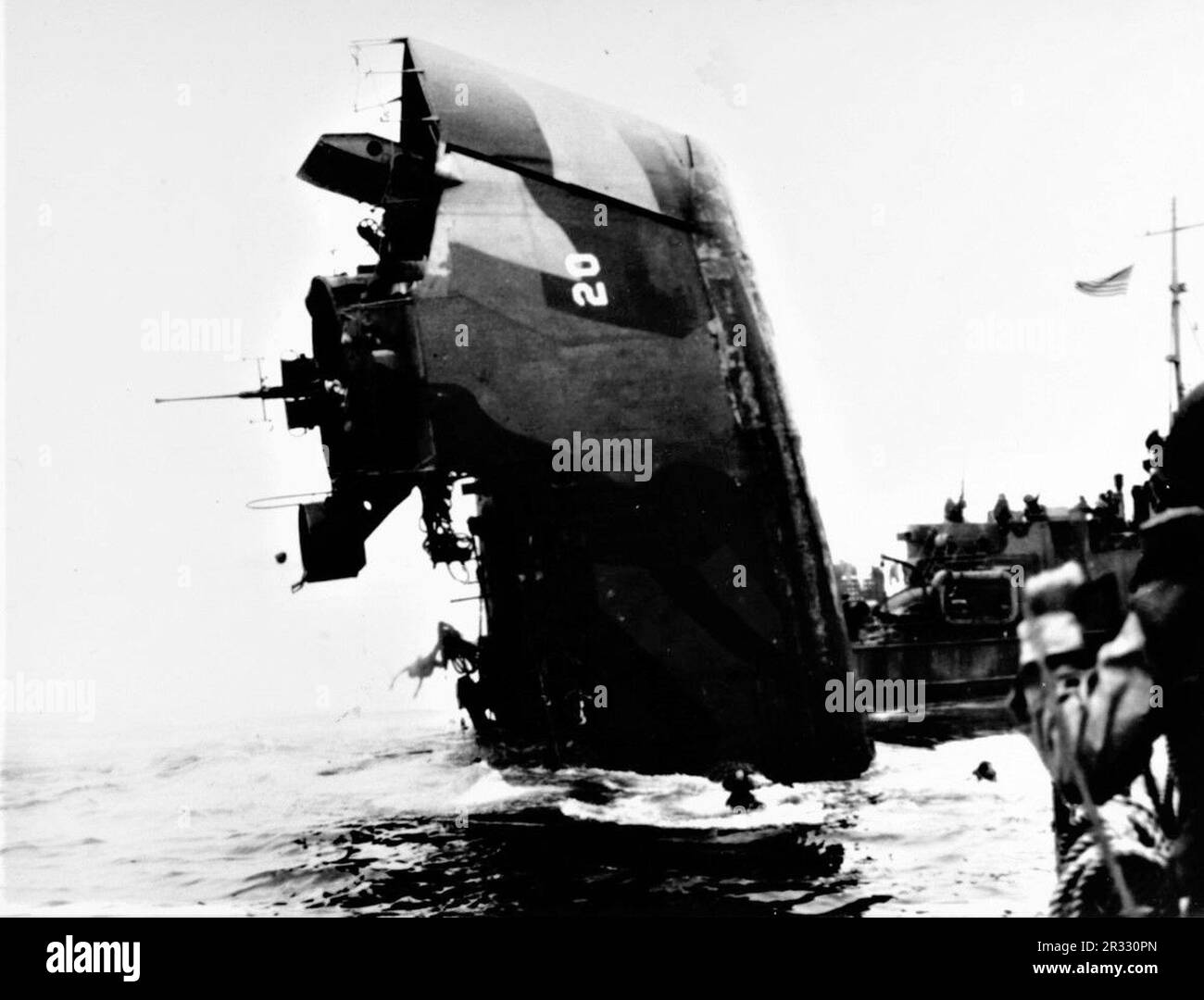 LSM (Landing Ship Medium) 20 sinkend in Surigao Straits, 5. Dezember 1944. Sie wurde von einem Kamikaze mitten in Schiffen getroffen, 8 Menschen getötet und 9 verletzt. Als Japan Ende 1944 mit einer Niederlage konfrontiert war, entschied es sich, US-Schiffe mit Selbstmordattentaten, bekannt als Kamikaze, zu zerstören. Diese Angriffe waren eine starke physische und psychologische Waffe und versenkten insgesamt 47 Schiffe zu einem Preis von mehr als 3000 Piloten und Flugzeugen. Ende 1944 war die US-Marine so groß, dass die Verluste unbedeutend waren und den Verlauf des Krieges nicht veränderten. Stockfoto