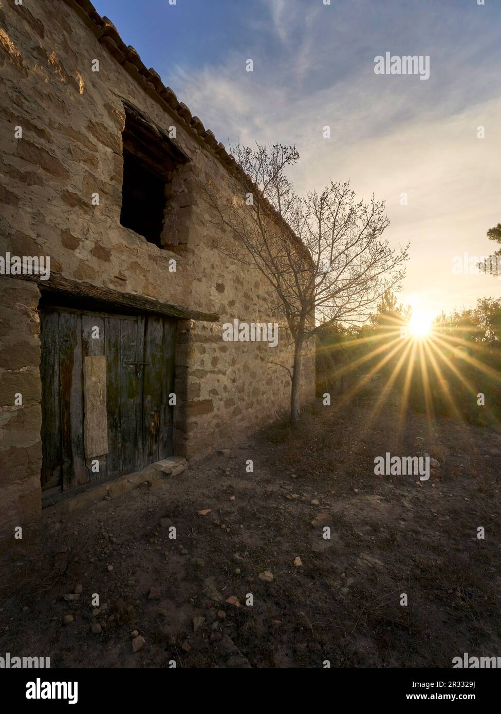 Ein verlassenes Landhaus mit der Sonne bei Sonnenaufgang Stockfoto