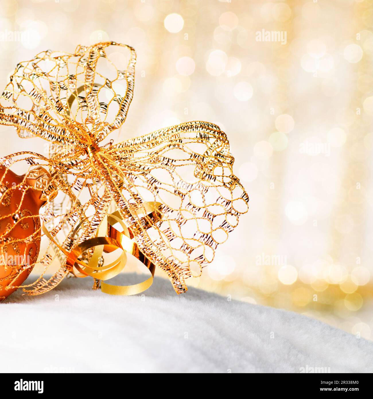 Goldener Weihnachtsball und Schleife Stockfoto