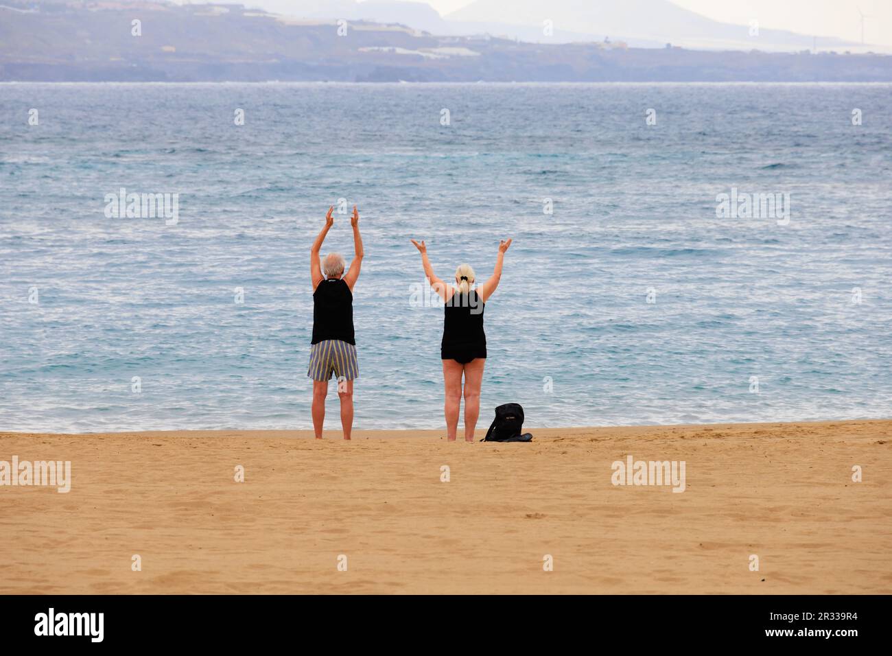 Ältere Paare üben Tai Chi am Strand von Playa de La Canteras. Las Palmas, Gran Canaria, Spanien Stockfoto
