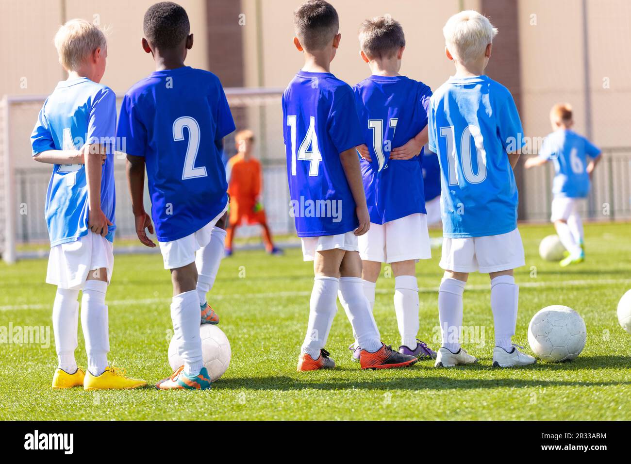 Fußball-Jugendmannschaft. Das Fußballteam übt Elfmeterball. Gruppenfoto. Fußballspieler, die beim Training zusammenstehen. Teamkollegen beim Fußball-Traini Stockfoto