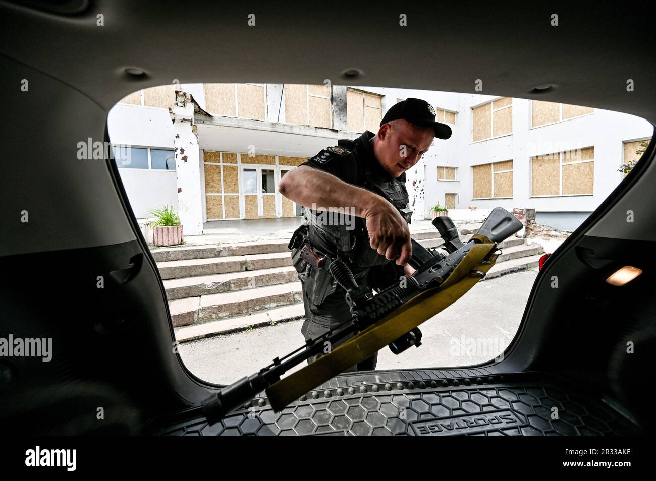 STEPNOHIRSK, UKRAINE - 19. MAI 2023 - Ein Gesetzeshüter legt ein Dienstgewehr in den Kofferraum des Wagens, Stepnohirsk, Region Zaporischzhien, Südostukraine Stockfoto