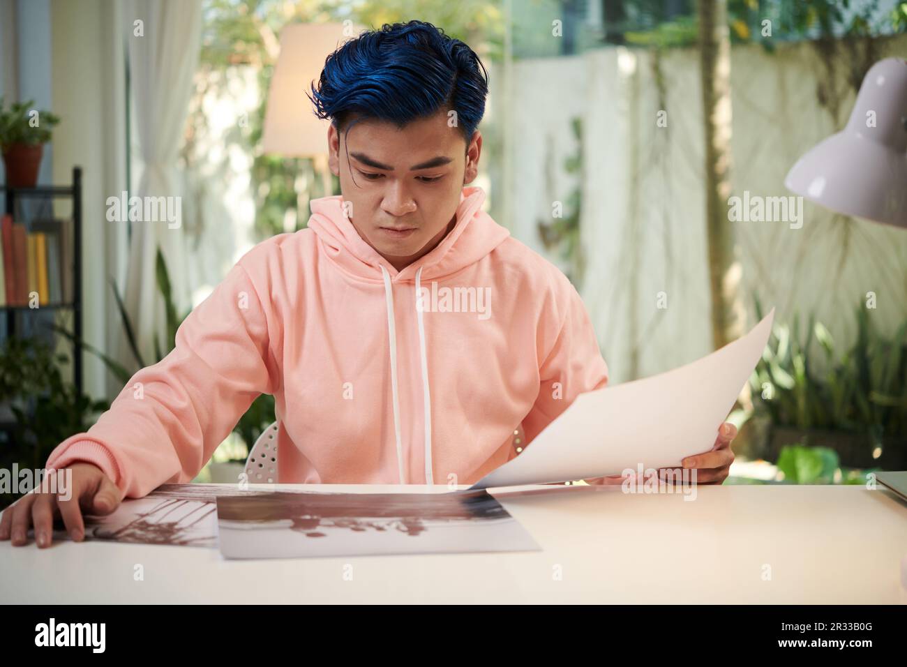 Ein junger Fotograf und Schwarzweißfotos, die er für die Ausstellung der Kunstgalerie druckte Stockfoto