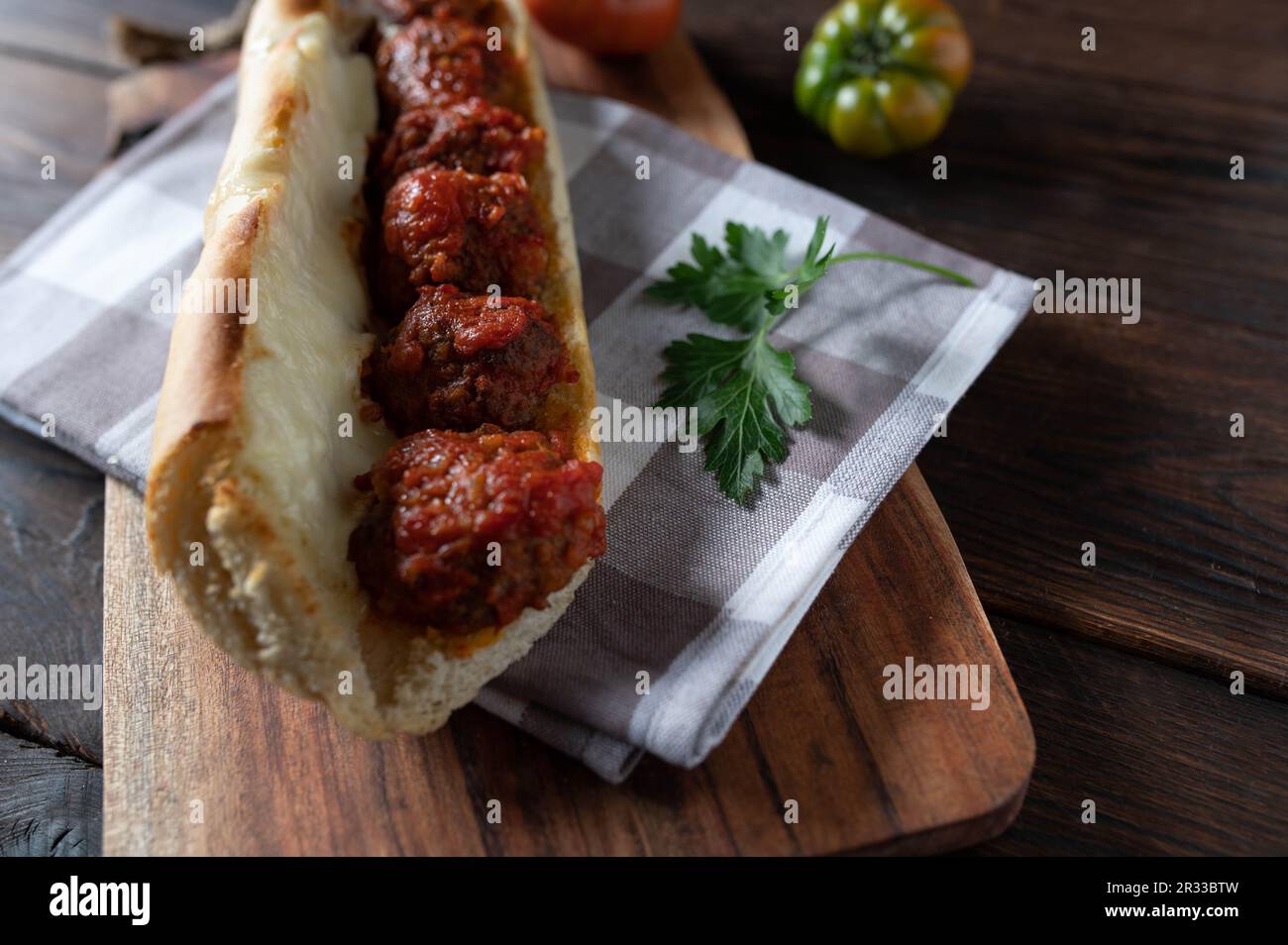Fleischbällchen-Sandwich mit Tomatensauce und geschmolzenem Mozzarella-Käse auf einem Holztisch. Stockfoto