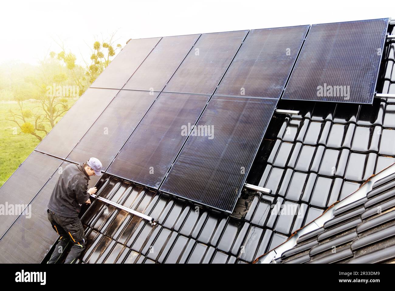 Techniker, der Solarpaneele auf dem Dach eines Hauses installiert Stockfoto