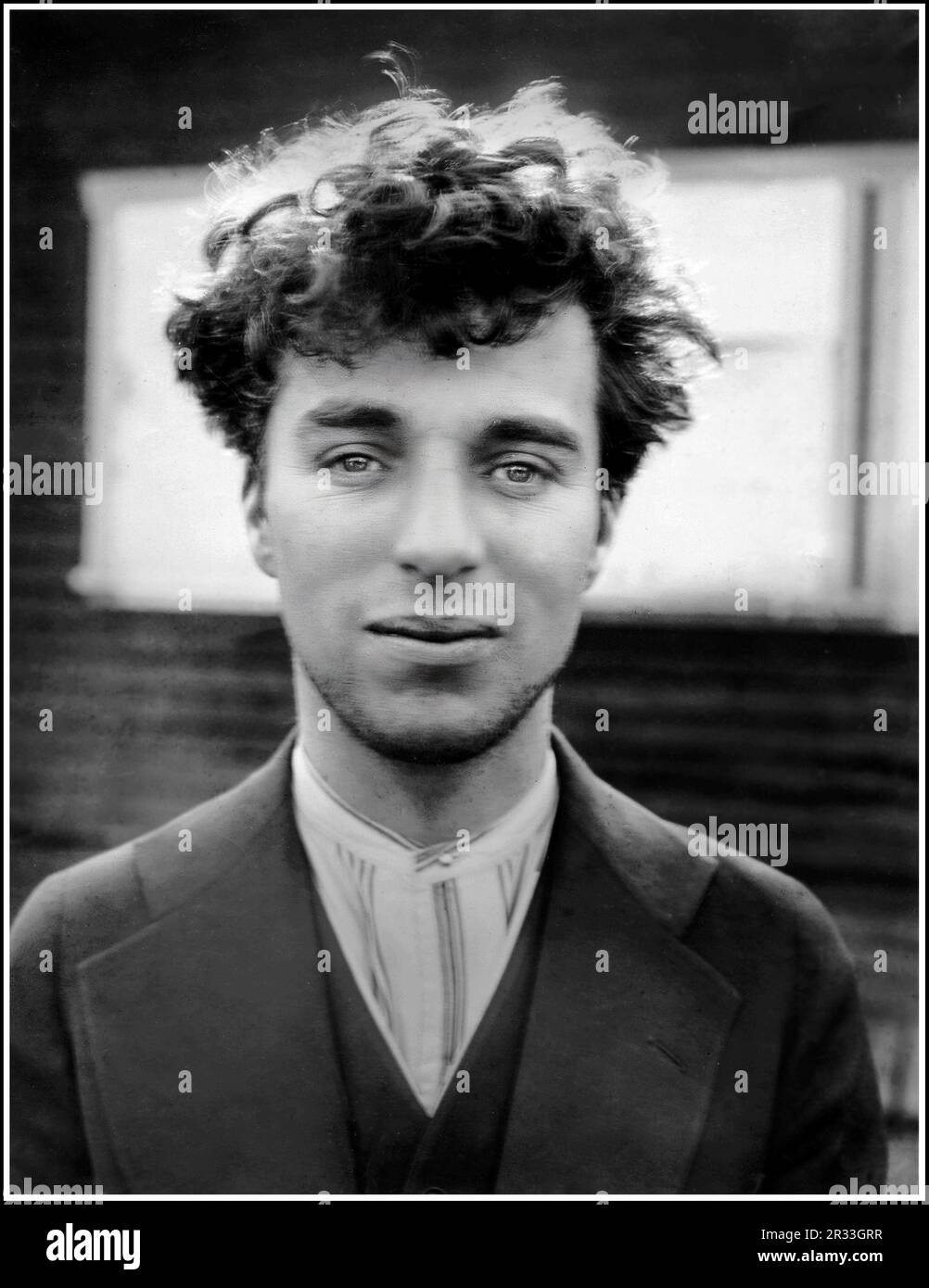 Charlie Chaplin 1900er Film Actor informelle Reportagen restaurierte das Schwarzweißporträt draußen, als ein junger Mann um 1916 aufgenommen wurde Stockfoto