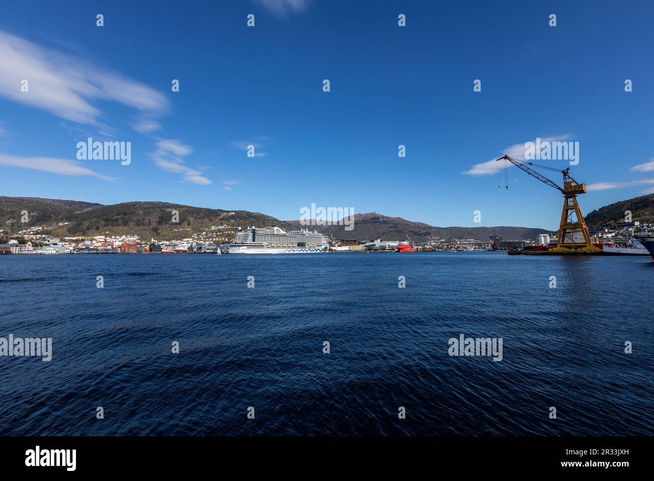 Kreuzfahrtschiff AIDAperla am Jekteviken Terminal im Hafen von Bergen, Norwegen. Mount Floeyen und Mount Ulriken im Hintergrund. Alte BMV-Werft auf der rechten Seite Stockfoto