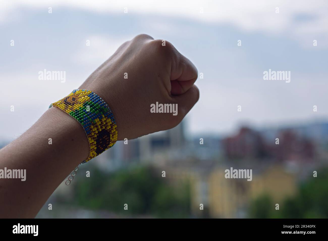 Armband mit Sonnenblumen an der Hand einer Frau. Symbol der unzerbrechlichen Ukraine Stockfoto