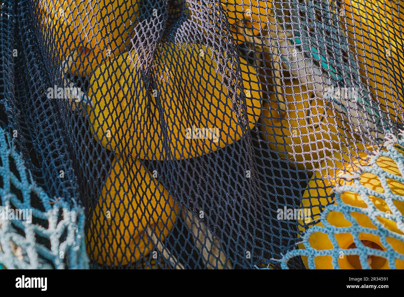 Fischnetz mit gelben Schwimmern trocknet auf dem Pier, Nahaufnahme, selektiver Fokus. Konzepte der Fischerei in Küstenstädten Stockfoto