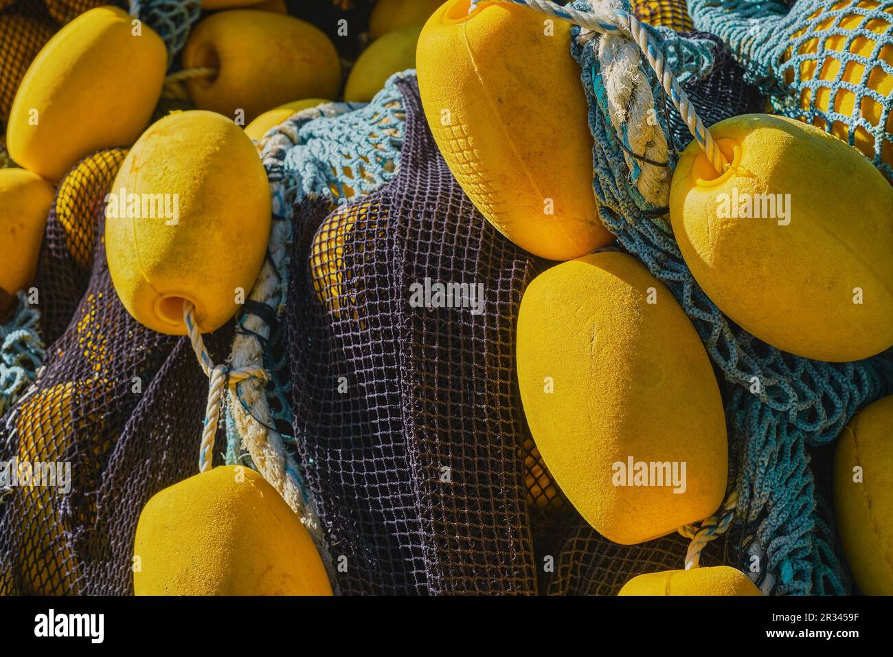 Hintergrund farbenfroher Fischernetze mit gelben Schwimmern, Nahaufnahme, selektiver Fokus. Hintergrund für das Konzept der traditionellen Fischerei in Küstenstädten Stockfoto