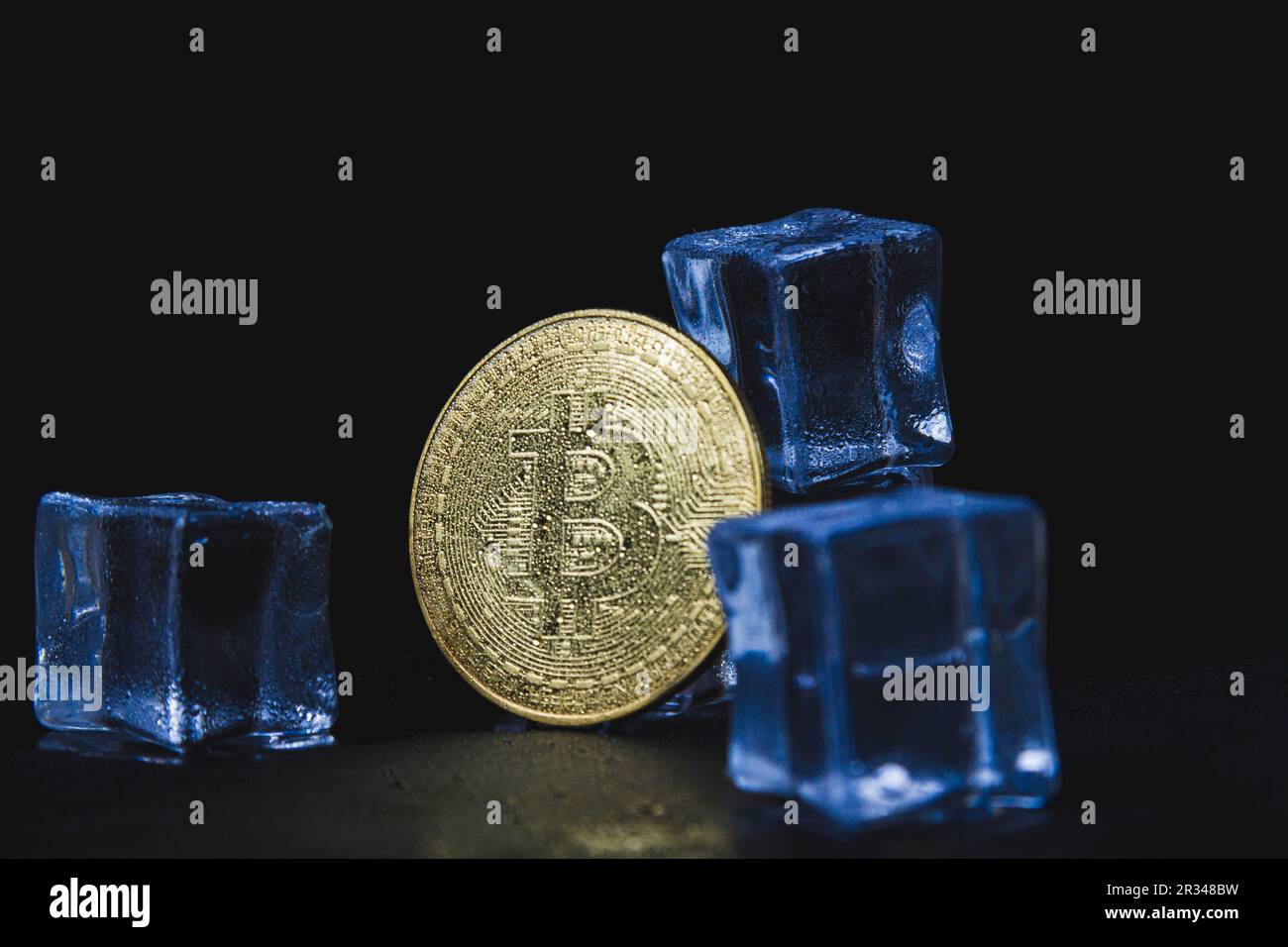 Eis und Bitmünze. Einfrieren von Konten mit Kryptowährung. Gefrorene Bitcoin-Münze. Stockfoto