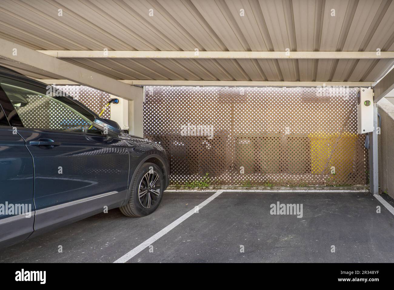 Ein Außenparkplatz mit Blechdach und Schnellladestationen für Elektrofahrzeuge Stockfoto