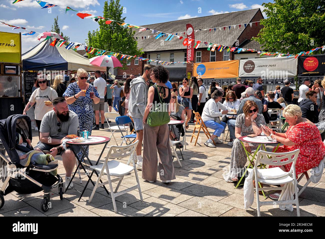 Leute essen auswärts und genießen das Sommerwetter auf dem Stratford upon Avon Sunday Market Warwickshire England Großbritannien Stockfoto