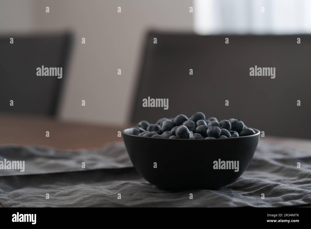 Große Schüssel mit Heidelbeeren auf dem Tisch, flacher Fokus Stockfoto