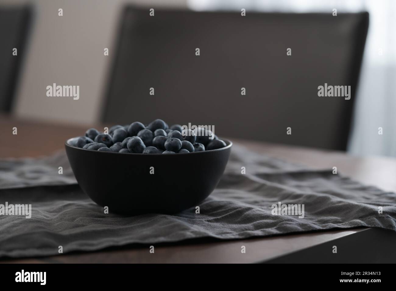 Große Schüssel mit Heidelbeeren auf dem Tisch, flacher Fokus Stockfoto