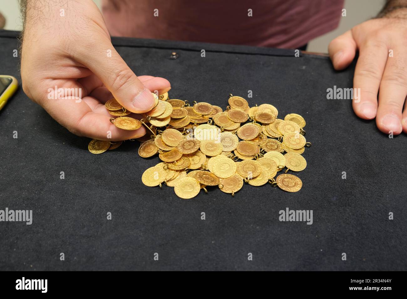 Männerhand mit türkischer Viertelmünze auf schwarzem Hintergrund. Stockfoto