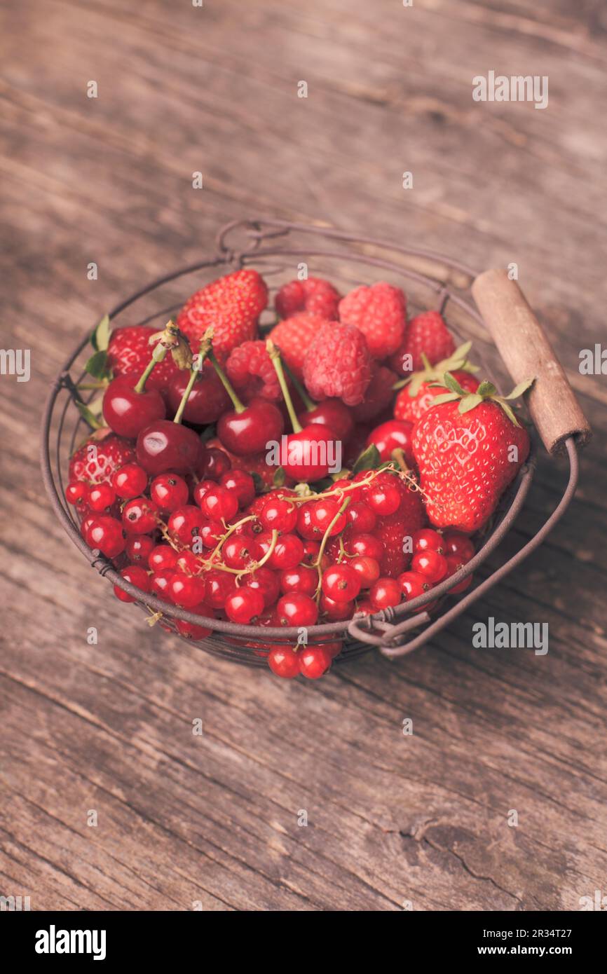Roten Sommerfrüchten im Metallkorb auf dem Tisch Stockfoto