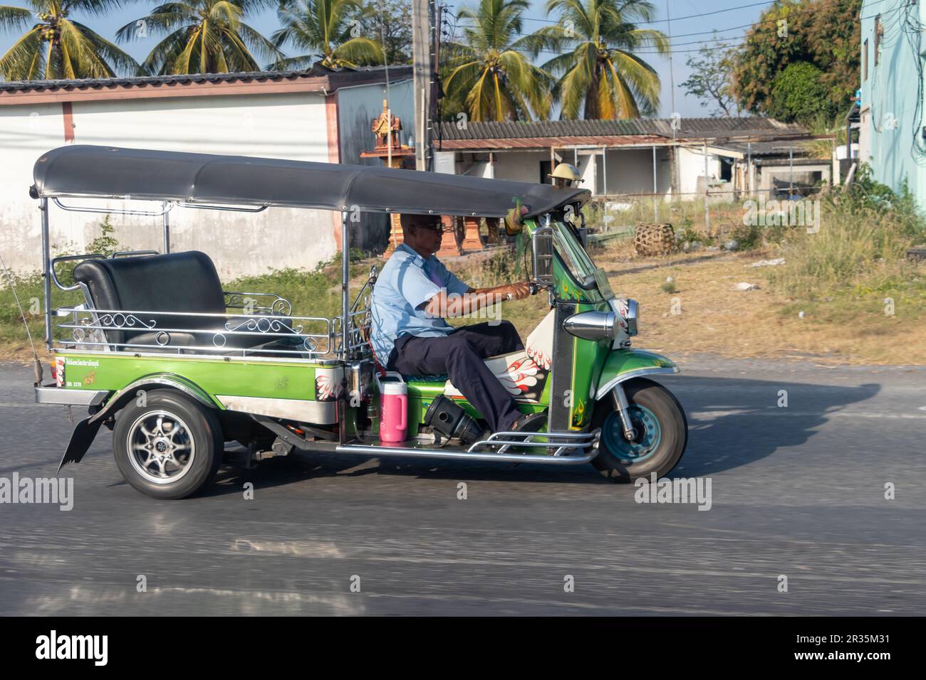 THAILAND, JANUAR 21 2023, Ein traditionelles Motordreirad - Tuk Tuk fährt auf einer Landstraße Stockfoto