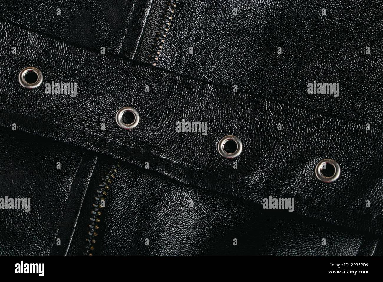Nahaufnahme aus Naturleder. Hintergrund schwarzer Lederbekleidung. Konstruktionselemente. Stockfoto