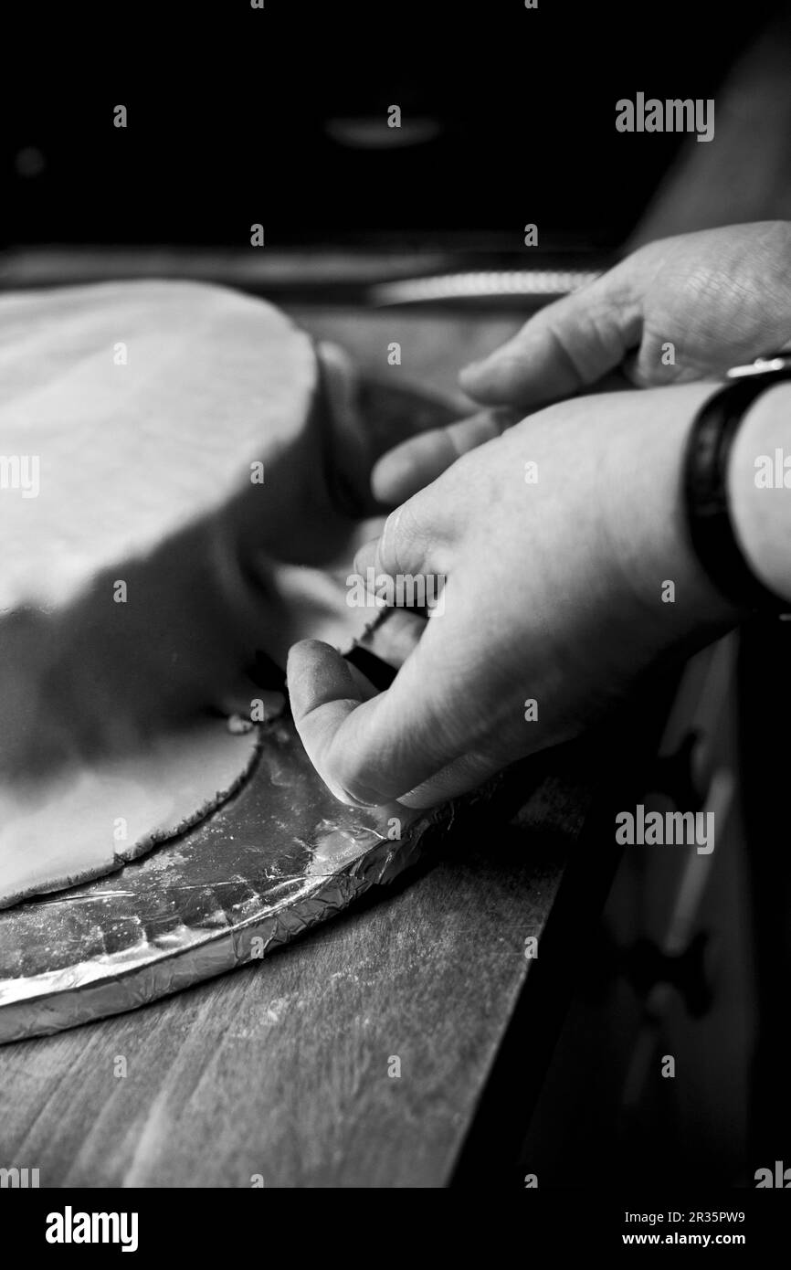 Eine Hochzeitstorte, die mit Fondantglasur bedeckt ist (Schwarz-Weiß-Foto) Stockfoto