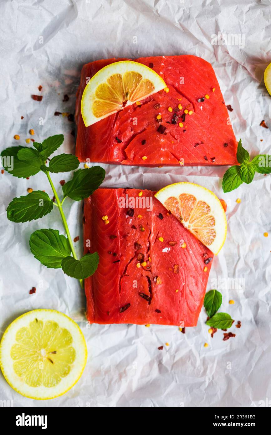 Raw Wildlachs mit Minze, Zitrone und Gewürzen auf ein Stück weißes Papier Stockfoto