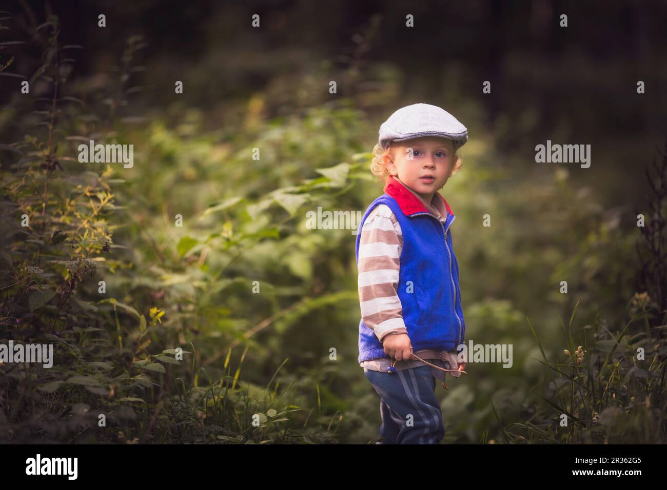 Kleiner Junge, der in der Natur spielt. Weißer Junge und grüne Landschaft. Stockfoto