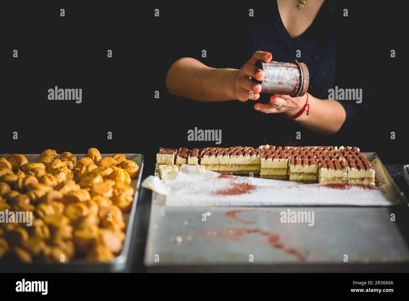 Tiramisù Sahnescheiben, die mit Kakao abgewischt werden Stockfoto