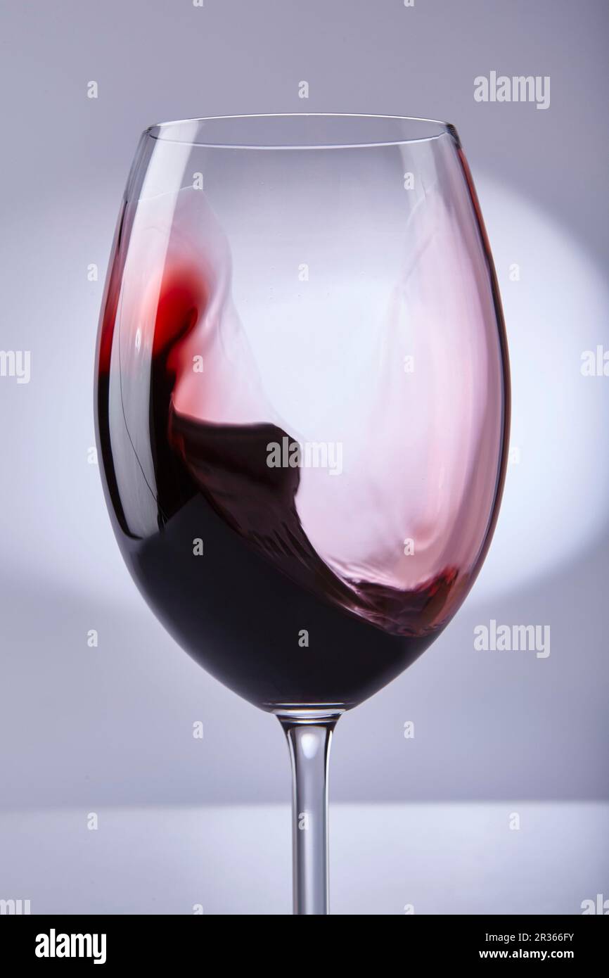 Rotwein swilling in einem Glas Stockfoto