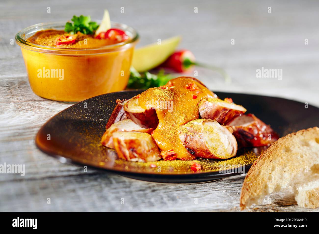 Currywurst mit Currypulver, Baguette und Chili Stockfoto