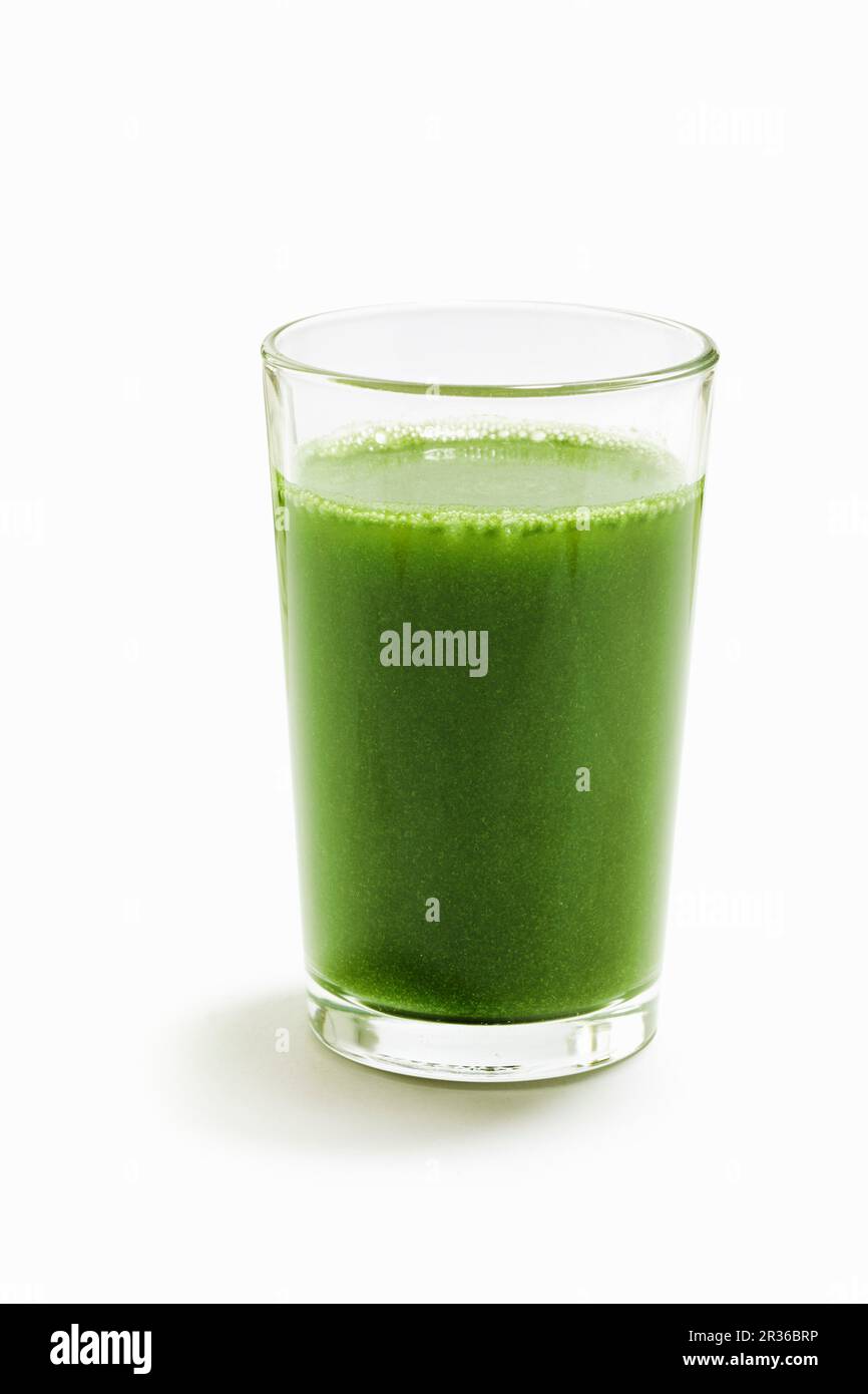 Ein grüner Weizengras-Smoothie auf einer weißen Oberfläche Stockfoto