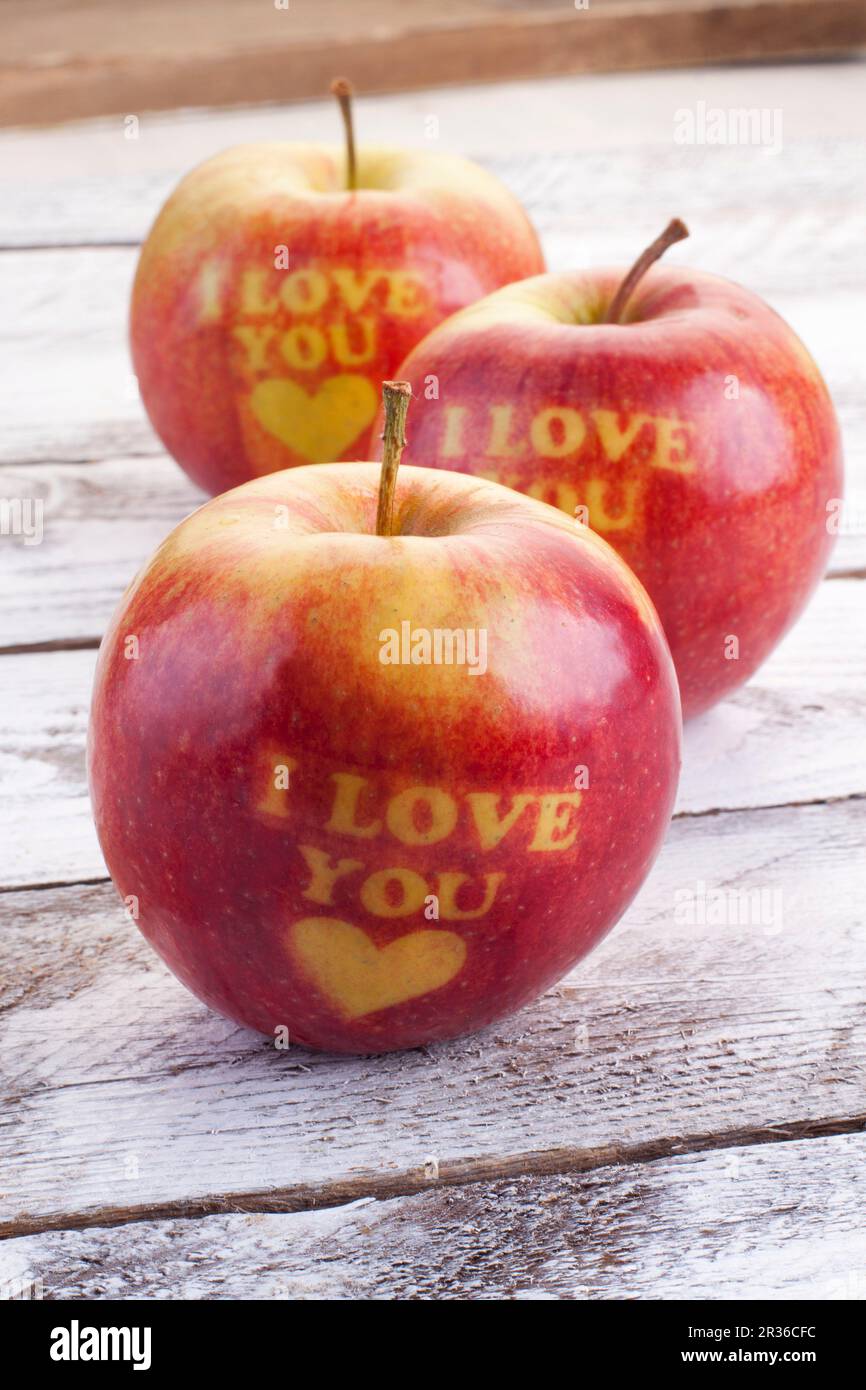 Drei rote Äpfel mit Herzen und die Worte "Ich liebe Dich" geschnitzt Stockfoto