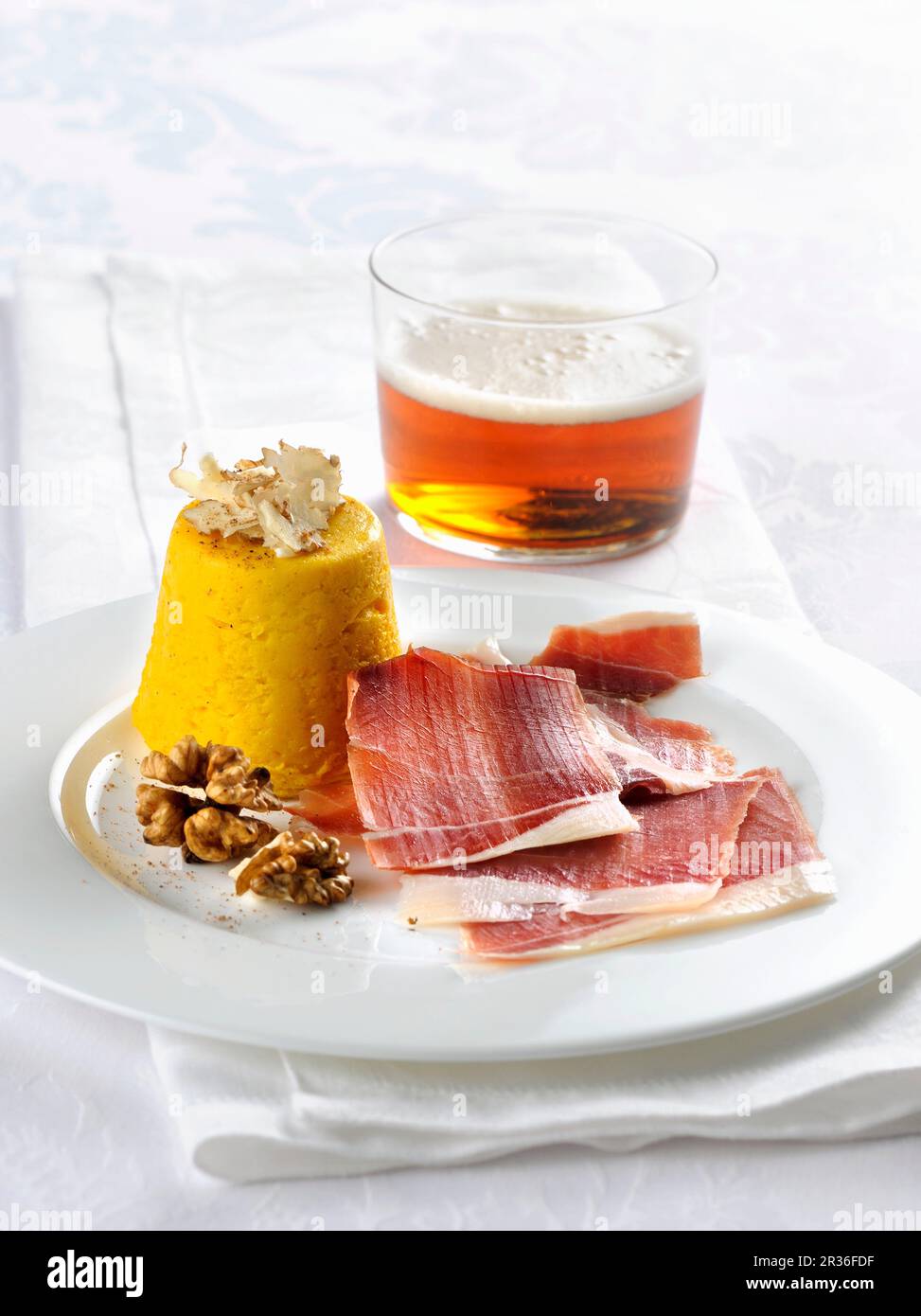 TrüffelKürbisflan mit geräuchertem Schinken und Walnüssen Stockfoto