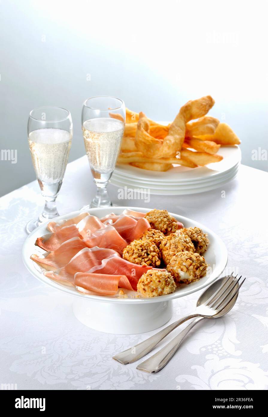 Parmaschinken und Robiola-Trüffel werden mit Prosecco serviert Stockfoto