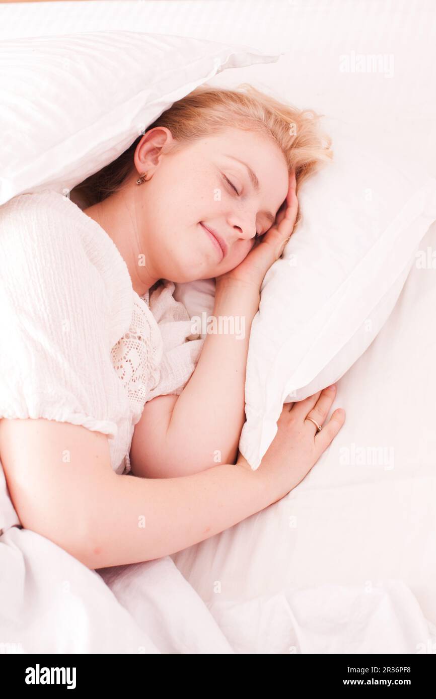 Frau im weißen Bett schläft Stockfoto