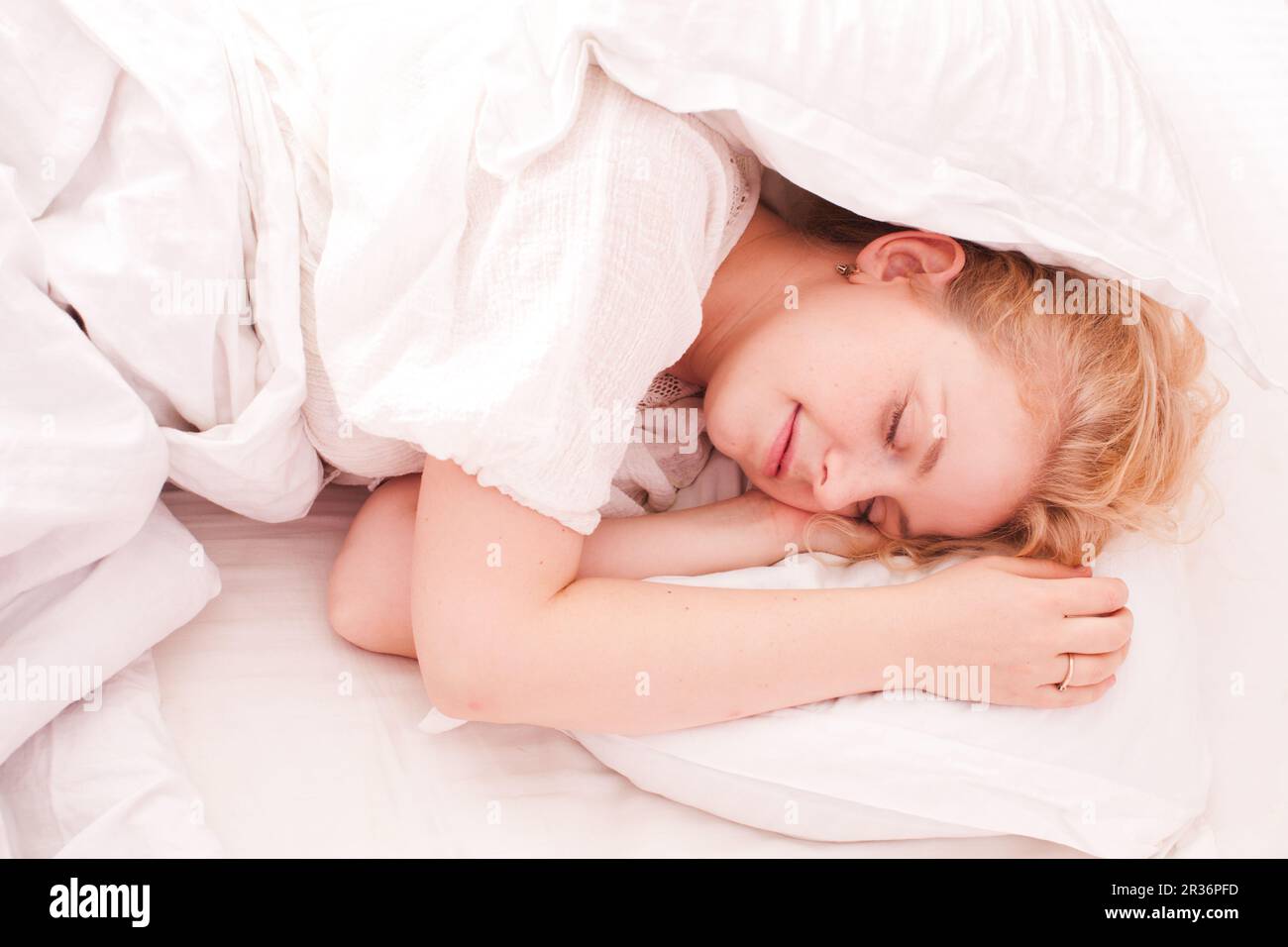 Frau im weißen Bett schläft Stockfoto