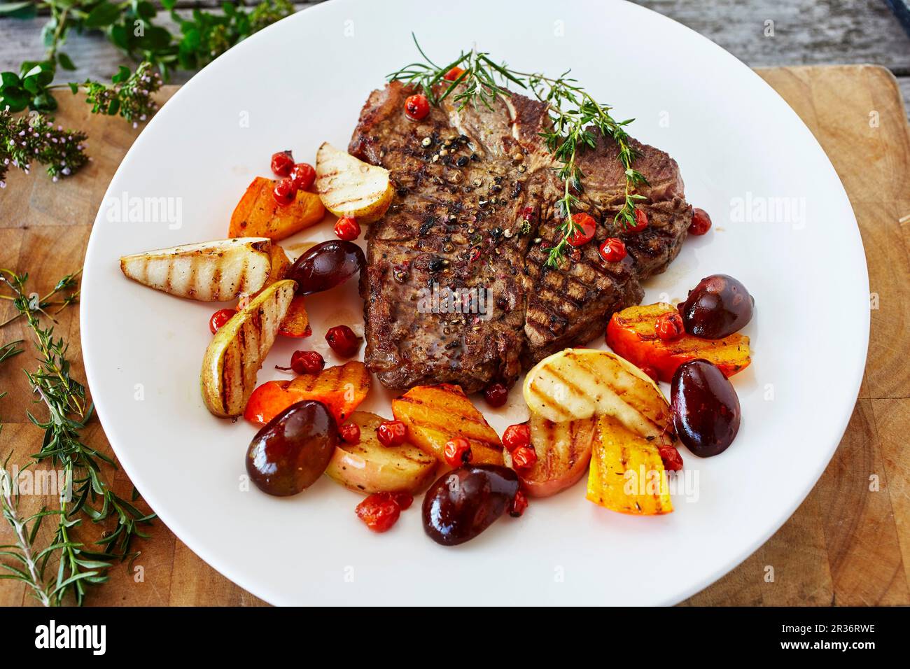 Ein T-Bone Steak mit glasiertem Obst und Kürbis Stockfoto