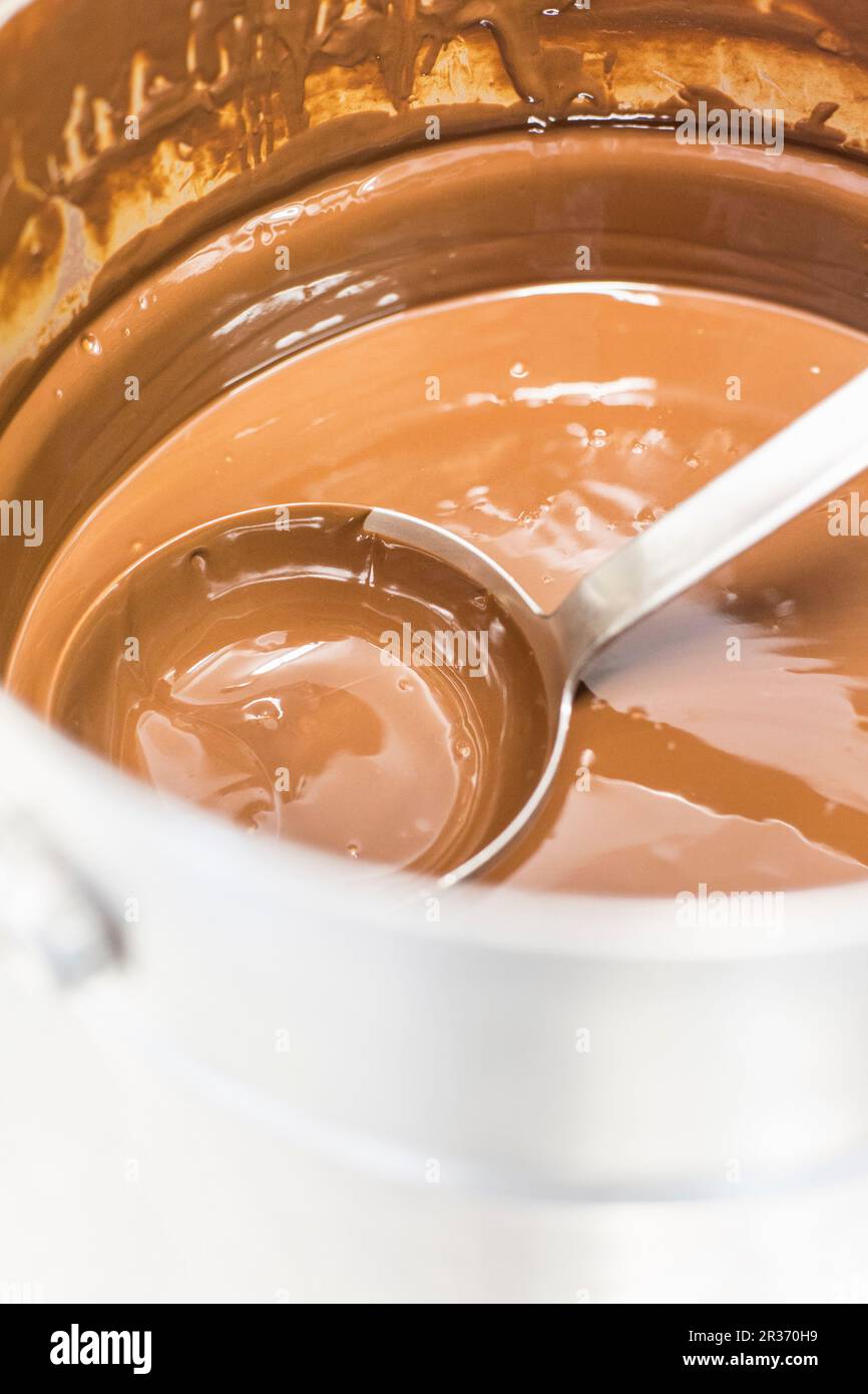 Schokoladensauce in einem Topf mit einer Pfanne Stockfoto