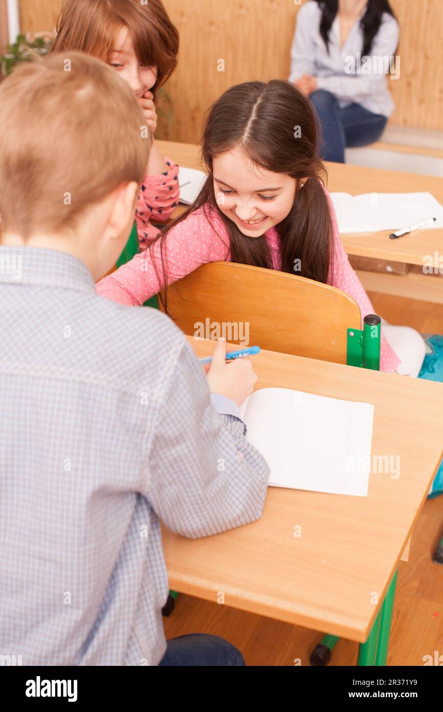 Schulmädchen erklären ihr Klassenkamerad Stockfoto