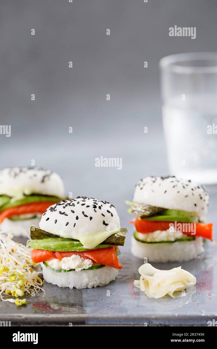 Drei Sushi-Burger mit geräuchertem Lachs, Gurke, frischem Käse, Wasabi, Nori und Avocado Stockfoto
