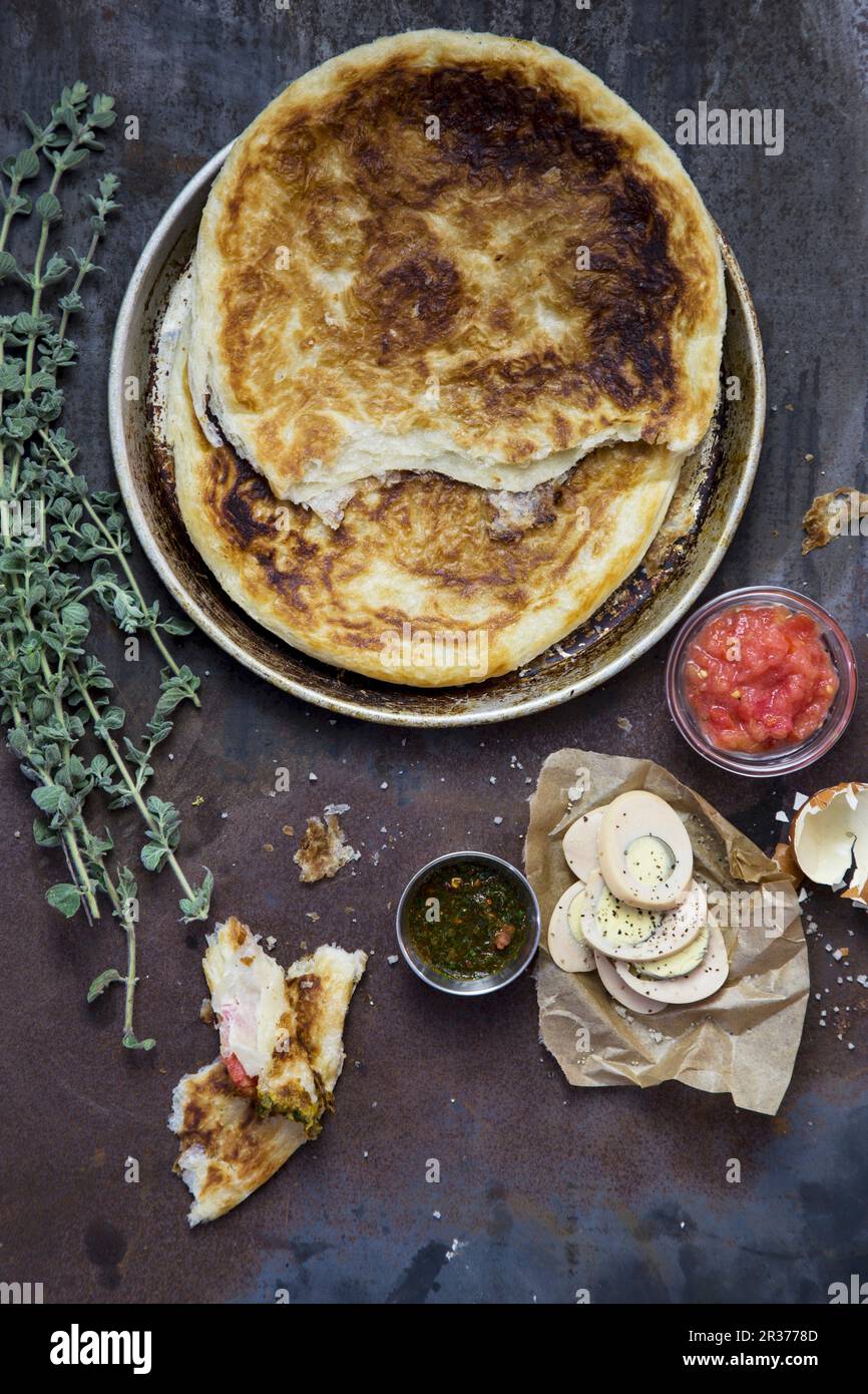 Fladenbrot, hart gekochte Eier, Tomaten und Thymian Stockfoto