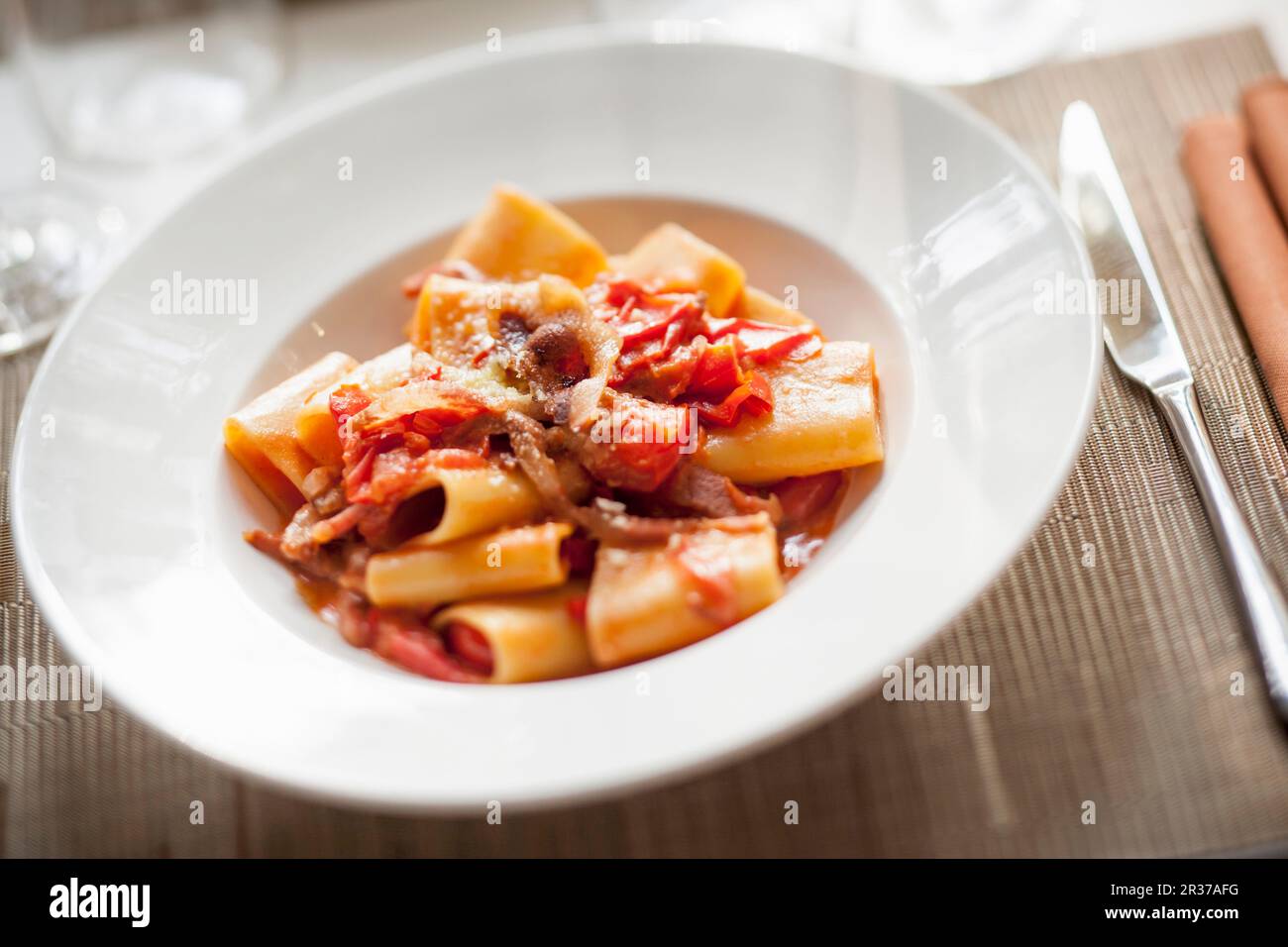 Pasta amatriciana mit Tomatensoße und Speck Stockfoto