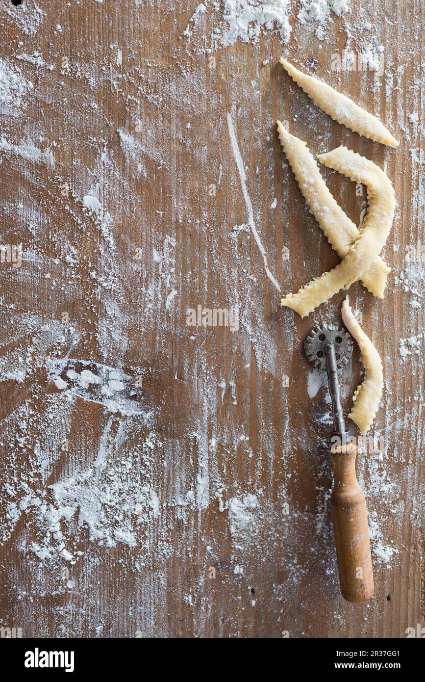 Stück Gebäck auf einem mehlten Holzbrett Stockfoto