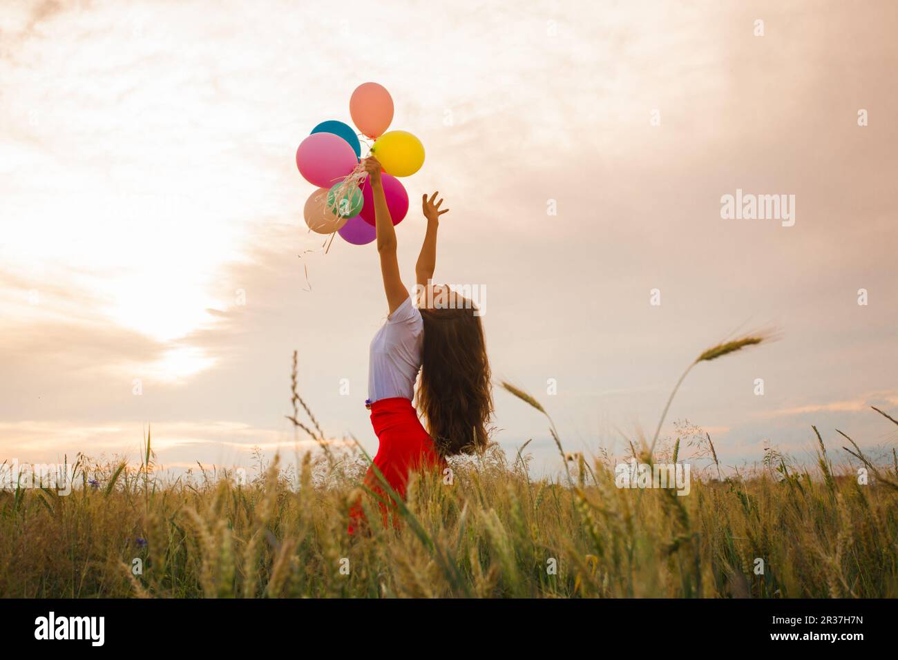 Mädchen mit Luftballons im Weizenfeld Stockfoto