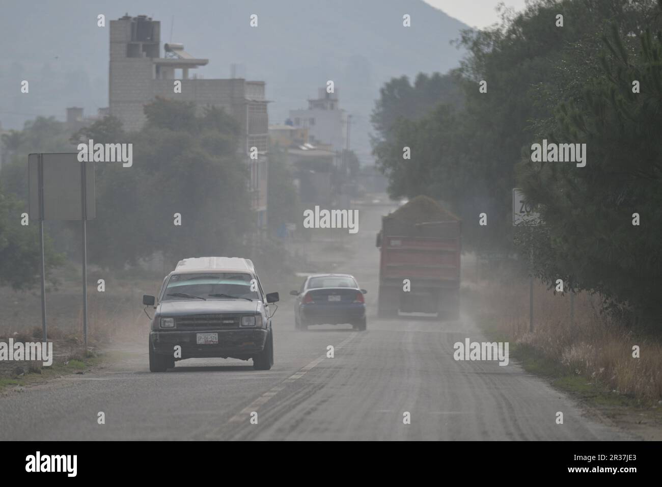 Puebla. 22. Mai 2023. Dieses Foto wurde am 22. Mai 2023 aufgenommen und zeigt Fahrzeuge, die durch die Asche fahren, die durch die Aktivität des Vulkans Popocatepetl im Bundesstaat Puebla, Mexiko, verursacht wurde. Am Sonntag erhöhten die mexikanischen Behörden die Alarmstufe aufgrund der jüngsten erhöhten Aktivität des Vulkans Popocatepetl. Die Alarmstufe wurde von der gelben Phase zwei auf die gelbe Phase drei erhöht, einen Schritt unter der roten Alarmstufe, sagte Laura Velazquez, Leiterin der mexikanischen Nationalen Katastrophenschutzbehörde, bei einer Pressekonferenz. Kredit: Xin Yuewei/Xinhua/Alamy Live News Stockfoto